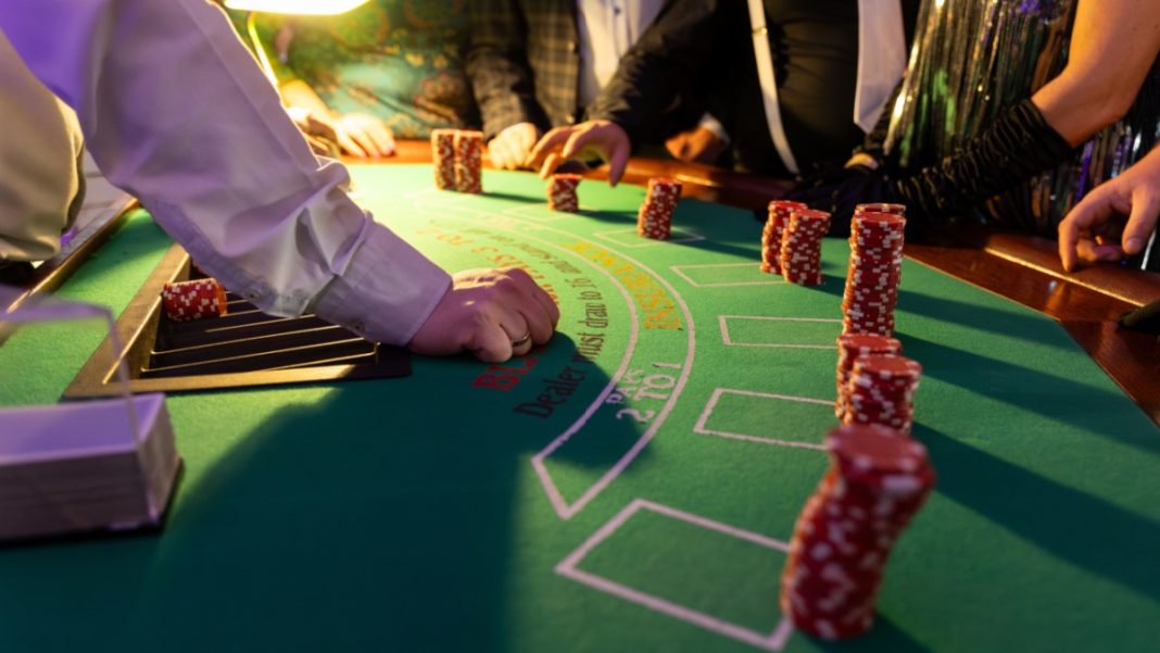 Players with stacks of chips at a blackjack table, some of the typical sights of a casino