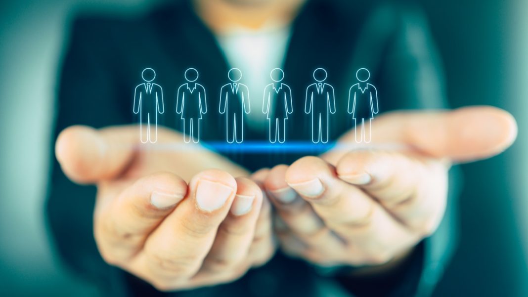 A businesswoman holds virtual people icons