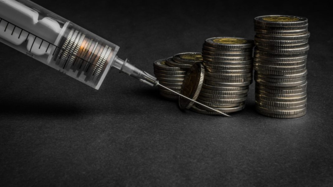 A stack of coins and a syringe, indicating a cash injection