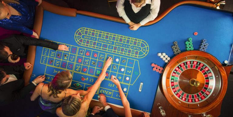 Mesa de roleta vista de cima com pessoas apostando