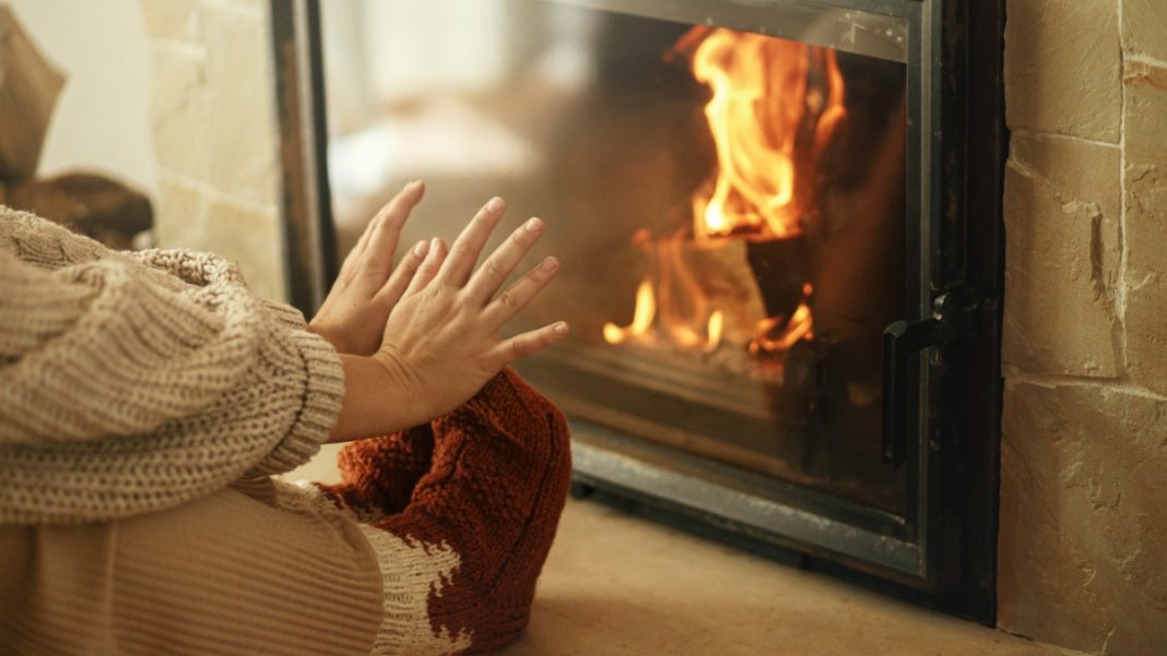 A person warms their hands by a fire