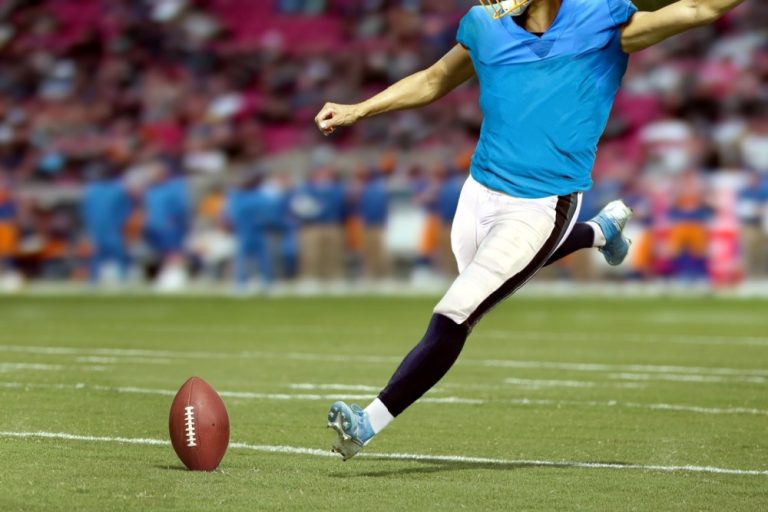 American footballer kicks ball