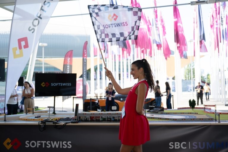 Woman holds flag with SOFTSWISS logp