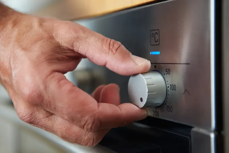 Hand turning up temperature of an oven